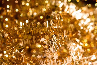 Güzel, soyut, parlak altın renkli arka plan, yıldızlı çelenk ve bokeh