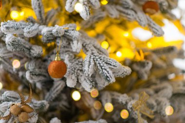 Arka planda Bokeh olan bir ağaçta noel topları, mutlu noeller, sığ alan derinliği, asla dekor giyme.