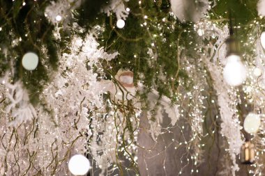 Mutlu Noeller ve yeni yıl tatili geçmişi. Ampuller ve Noel ağacı dallarıyla bulanık bokeh arkaplan