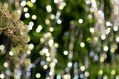 Mutlu Noeller ve yeni yıl tatili geçmişi. Ampuller ve Noel ağacı dallarıyla bulanık bokeh arkaplan