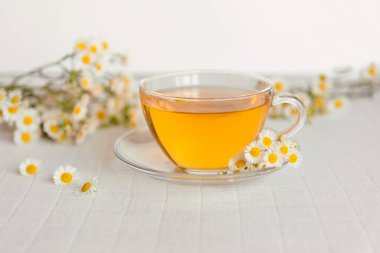 Papatya çiçekli bir fincan bitki çayı.