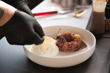 Şef et hazırlıyor, kapari, çiğ yumurta, krem şanti, gurme