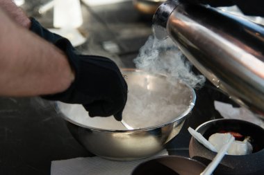 Aşçıbaşı dondurma yapıyor. Sıvı nitrojen ekliyor. Dondurma tatlısı yapma süreci.