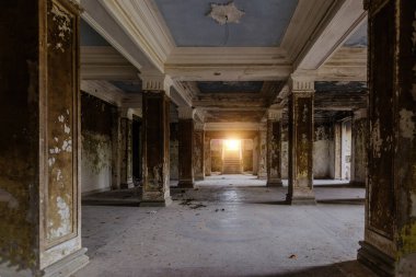 Eski terk edilmiş malikanede sütunları olan büyük bir salon.