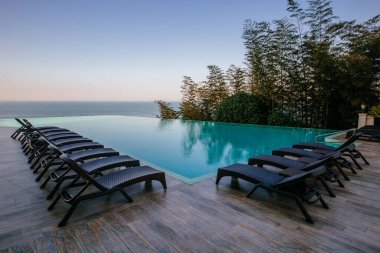 Swimming pool with beach chairs in luxury hotel.