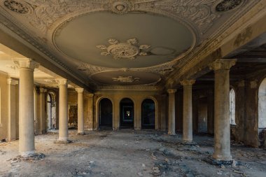 Eski terk edilmiş malikanede sütunları olan büyük bir salon..