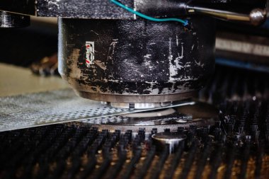 CNC yumruk ve kemirme makinesi ve delinmiş çelik levha, kapatın..