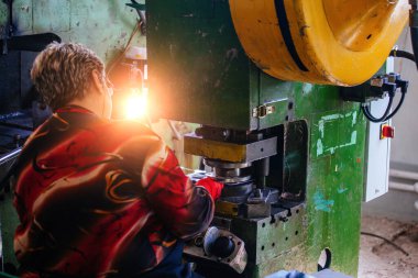 Metal baskı makinesi kullanan kadın işçi, kapatın..