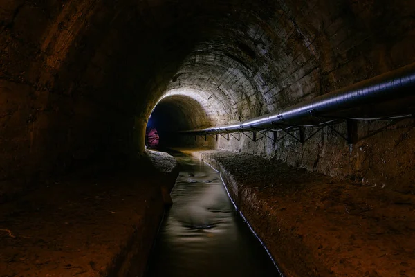地下のアーチ型の都市下水道トンネルと汚い下水 — ストック写真