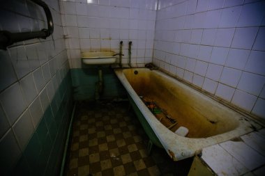 Terk edilmiş hastanedeki ürkütücü banyo odası. Kırmızı ışık, korku konsepti.