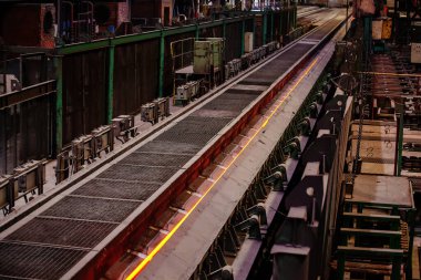 Yuvarlanan metal fabrikası sıcak çelik çubuğu konveyörde hareket ediyor..