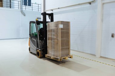 Modern depoda taşınan forklift yükleyicisi, hareket bulanıklığı..