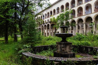 Ruined overgrown old abandoned Soviet sanatorium Iveria, Tskaltubo, Georgia. clipart