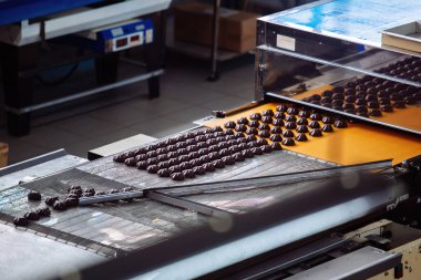 Çikolata jöleli şekerlemelerin konveyör makinesindeki şekerlemelerle işlenişi, kapatın..