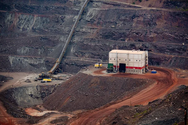 Large conveyor belt in open pit mine for ore transportation.