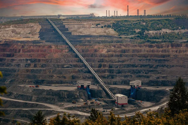 Large conveyor belt in open pit mine for ore transportation.