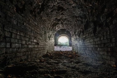 Tarihsel yeraltı kırmızı tuğla geçidi. Tünelin sonundaki ışık