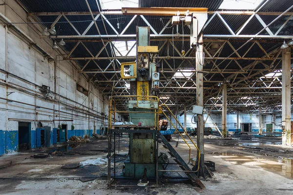 Terk edilmiş fabrika. Bozuk ekipman kalıntılarıyla bomboş bir sanayi salonu..