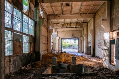 Yıkımı bekleyen çöplerle dolu büyük sanayi salonunu terk ettim..