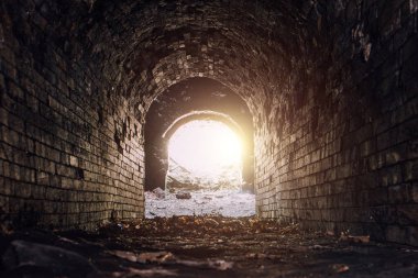 Tarihsel yeraltı kırmızı tuğla geçidi. Tünelin sonundaki ışık.