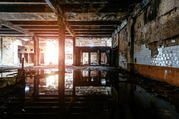 Dark flooded rotten abandoned industrial building.