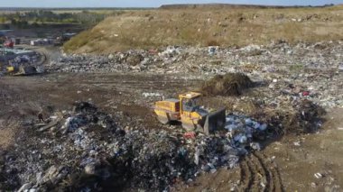 Çöp yığını, çalışan çöp kamyonu, buldozer, hava manzarası..