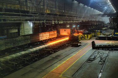 Yuvarlanan metal fabrikası. Sıcak demir levha, metal yuvarlanan değirmenin taşıyıcısında hareket ediyor..