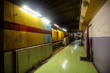 Experimental equipment of hadron collider in long corridor. Old industrial facility with technology for physics tests. clipart