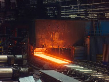 Yuvarlanan metal fabrikası. Sıcak demir levha, metal yuvarlanan değirmenin taşıyıcısında hareket ediyor..
