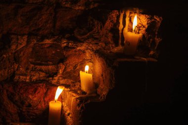 Eski şatonun kırmızı tuğla duvarında mumlar.