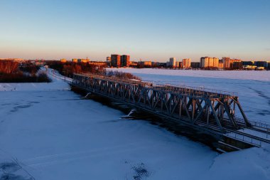 Kış mevsiminde Voronezh nehrinin üzerindeki demiryolu köprüsünün üzerinde gün batımı.