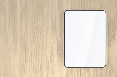 Tablet with empty screen on wooden desk, top view