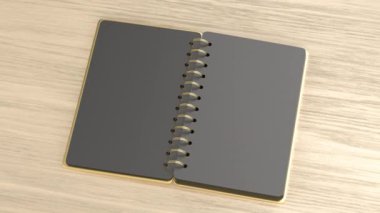 Tahta masanın üzerinde boş siyah sayfalar olan altın sarmal defter