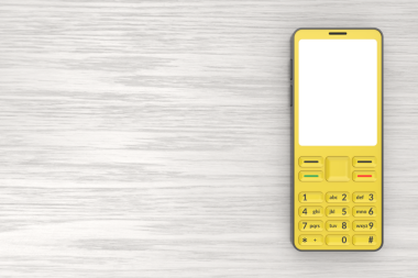 Sarı cep telefonu, ahşap masa üzerinde boş ekran, üst görünüm