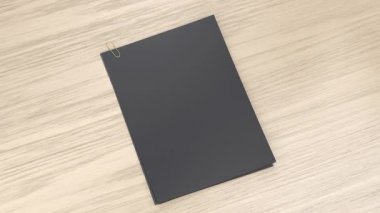 Tahta masaya ataç iliştirilmiş boş siyah kağıtlar.