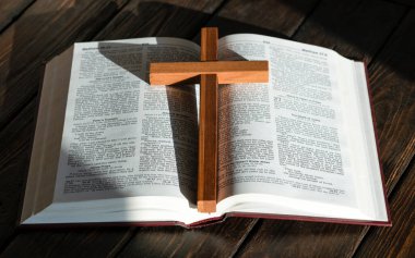 wooden cross and bible on wooden background