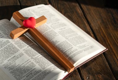 wooden cross and bible on wooden background