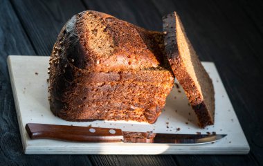 Siyah bir zemin üzerinde tahta bir tahta üzerinde siyah ekmek