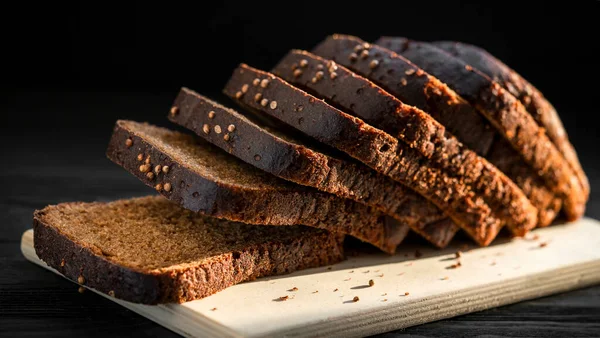 Черный Хлеб Деревянной Доске Черном Фоне — стоковое фото
