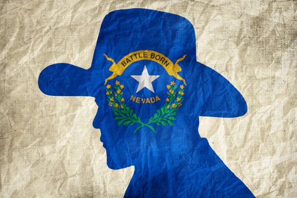 stock image Cowboy silhouette with Nevada flag on wrinkled paper background