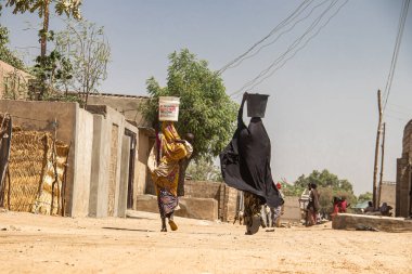 Typical life scene and photography of streets of small African town in remote area, with busy street vendors and shops, crowd of busy people , children playing around and local transportation