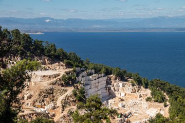 Daha fazla kullanım ve üretim için değerli taşı çıkarmak ve çıkarmak için kullanılan ağır makinelerle dolu beyaz mermer bir maden ocağı. Bir sorgunun her bloğu 5 tonluk ağır mermer.