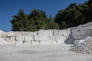 Daha fazla kullanım ve üretim için değerli taşı çıkarmak ve çıkarmak için kullanılan ağır makinelerle dolu beyaz mermer bir maden ocağı. Bir sorgunun her bloğu 5 tonluk ağır mermer.