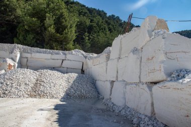Daha fazla kullanım ve üretim için değerli taşı çıkarmak ve çıkarmak için kullanılan ağır makinelerle dolu beyaz mermer bir maden ocağı. Bir sorgunun her bloğu 5 tonluk ağır mermer.