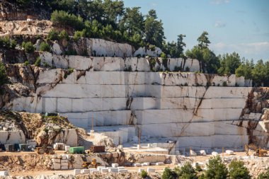 Daha fazla kullanım ve üretim için değerli taşı çıkarmak ve çıkarmak için kullanılan ağır makinelerle dolu beyaz mermer bir maden ocağı. Bir sorgunun her bloğu 5 tonluk ağır mermer.