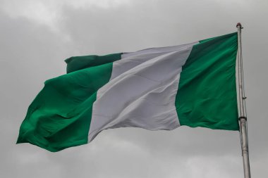 Nigerian flag, with three vertical bands of green, white, green. The two green stripes represent natural wealth, and the white represents peace and unity clipart