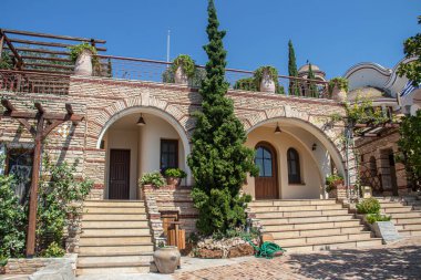 View on backyard of Monastery of Archangel Michael in Greece, Thasos Island, with vivid orange walls and roof, monastery was build at the cliff over the Aegean Sea, which first began as a men's only monastery at the start of the 20th century