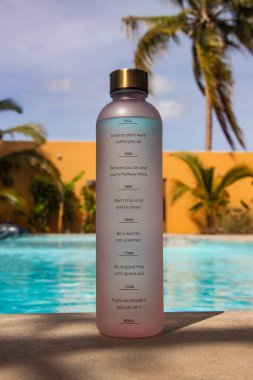 Yüzme havuzunun yanındaki grafiksel su şişesi, ilham verici yaşam ve sağlık mesajlarıyla sağlıklı bir hayatı destekliyor ve yeterince su içilmesini hatırlatıyor.