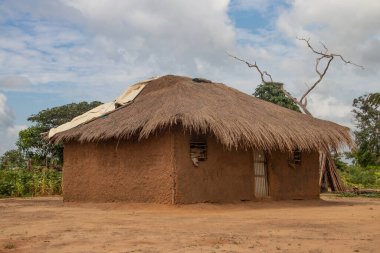 Afrika 'nın ücra bir köyünde sazdan çatılı, çok basit ve kötü yaşam koşulları olan tipik bir kırsal çamur evi.