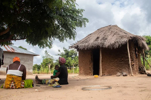 Makonde部落的女士们和她们的孩子坐在原始厨房的小木屋外面 准备当地的传统食物 石子之间简单的金属罐着火 — 图库照片